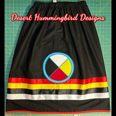 a black skirt with red, yellow, and blue designs on the bottom that says desert hummingbird designs