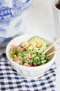 a white bowl filled with food next to a blue and white vase