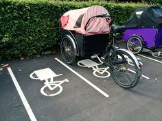 two bicycles parked next to each other in a parking lot with covers over the bikes