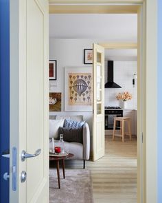 an open door leading to a living room and dining room with blue trim on the walls