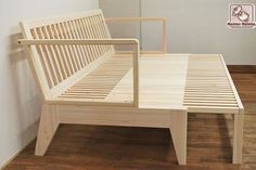 a wooden bench sitting on top of a hard wood floor next to a white wall