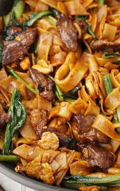 stir fried noodles with beef and vegetables in a pan