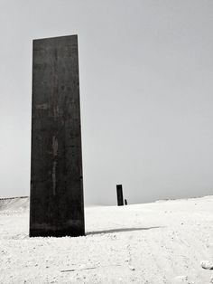 a black and white photo of a tall object in the snow