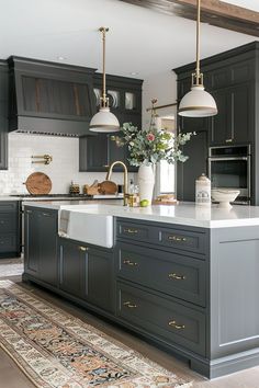 a large kitchen with gray cabinets and white counter tops, an island in the middle