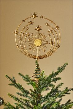 a small christmas tree with gold stars on it's top and a star ornament in the middle