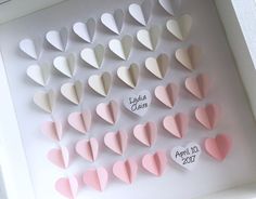 there are many hearts on the wall with name tags attached to them, all in different colors