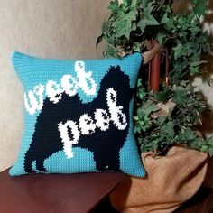 a dog pillow sitting on top of a wooden table next to a potted plant