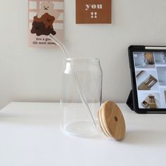 a glass with a straw in it sitting on a table next to a wooden coaster