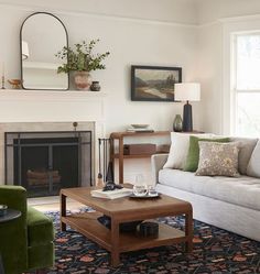 a living room filled with furniture and a fire place in front of a mirror on the wall