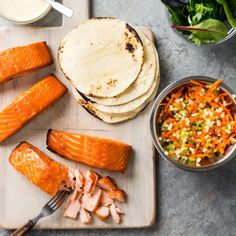 salmon, carrots, and other foods on a cutting board