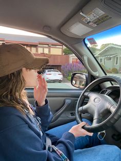 a woman sitting in the driver's seat of a car