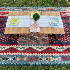 the table is set with two plates and a potted plant on top of it