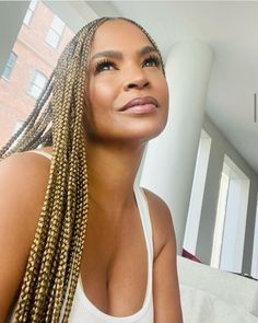 a woman with long braids sitting on a couch