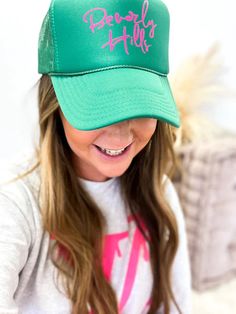 Top off your look with this stylish, Beverly Hills-approved trucker hat! The bright green color features a bright splash of pink lettering - guaranteed to turn heads. Perfect for a day outdoors, this hat is the ultimate accessory for a mood to match the sunny weather!