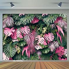 a wall with pink and green tropical leaves on it in an empty room that has wooden flooring