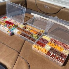 a table filled with lots of different types of food on top of a brown couch