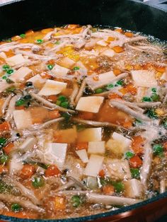 a pot filled with soup sitting on top of a stove