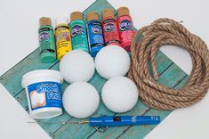 the supplies needed to make an art project are laid out on a wooden board and rope