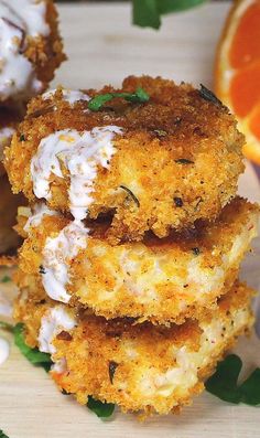 three fried food items stacked on top of each other with garnishes and orange slices