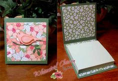 an open card box with a pink bird on it and flowers in the background, sitting on a wooden table