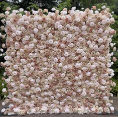 an artificial flower wall in the shape of a square, with pink and white flowers on it