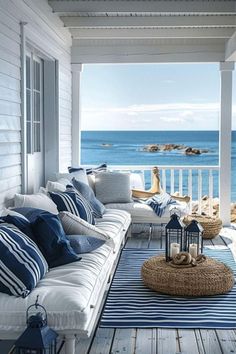 the porch is decorated with blue and white striped pillows, wicker furniture, and an ocean view