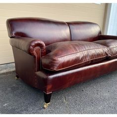 a brown leather couch sitting in front of a building