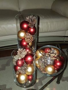 two glass vases filled with ornaments on top of a table next to a couch