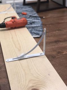 a piece of plywood being cut with a power tool on the floor next to it