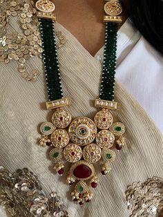 The red beads strings with an elegant pendant with Kundan and zirconium embellishments make this necklace a statement royal wedding set.  Notice the beautiful multicolored stones on the stunning pendant.  The stylish Kundan earrings complete the celebrated look. Material: Meticulously crafted from high-quality brass, copper, gold polish, Kundan work this necklace set combines durability with a brilliant, enduring shine. Necklace Dimensions: Weight: 155 grams Drop Length: 12 inches. Closure Type: Luxury Heavy Chandbali Kundan Necklace, Luxury Kundan Long Beaded Necklace, Luxury Bohemian Kundan Pendant Necklace, Luxury Yellow Gold Kundan Pendant Necklace, Elegant Kundan Necklace With Detachable Pendant For Festive Occasions, Festive Chandbali Bridal Necklace With Jeweled Details, Elegant Beaded Chandbali Kundan Necklace, Traditional Ruby Beaded Necklace, Traditional Round Bridal Necklace With Stones