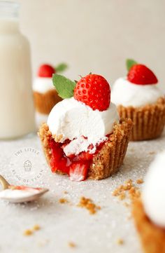 small desserts with strawberries and whipped cream on them