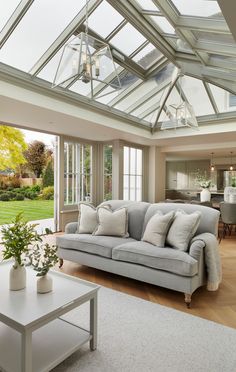 a living room filled with furniture and a skylight over the couches in front of it