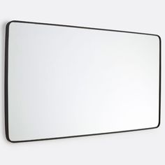 a mirror mounted to the side of a wall with a black frame and white background