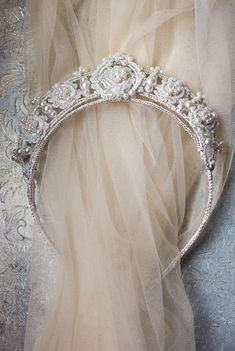 the tiara is adorned with pearls and swarong on it's head