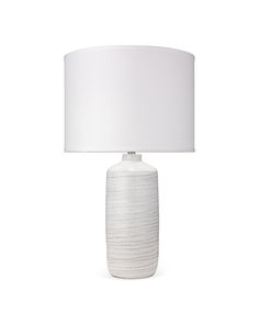 a white table lamp with a white shade on the base and a white fabric lampshade