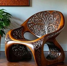 a wooden chair sitting on top of a hard wood floor next to a potted plant