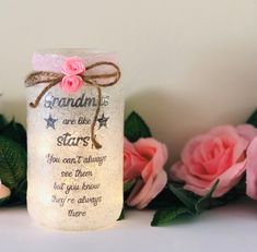 some pink roses are next to a jar that says grandma is the star you can't always see