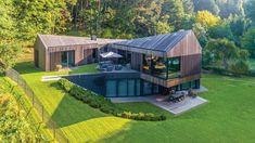 an aerial view of a house in the middle of a lush green field with trees