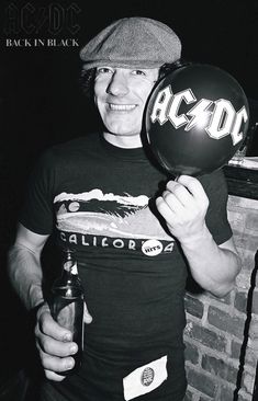 a man holding up a balloon with the word ac / dc on it in front of his face