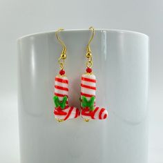 a pair of red and white candy cane earrings