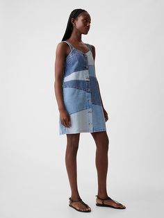 a woman wearing a denim dress and sandals