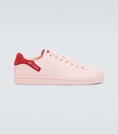 In a classic tennis shoe silhouette, these pastel pink sneakers from Raf Simons feature a silver-tone logo-print detail on red heel counters, and rest on rubber soles. | Raf Simons Orion sneakers Pink Leather High-top Sneakers With Vulcanized Sole, Pink Leather High-top Sneakers With Rubber Sole, Pink Leather Sneakers With Rubber Sole, Pink Leather High-top Sneakers With Contrast Sole, Pink Sneakers With Red Sole For Streetwear, Classic Pink Sneakers For Streetwear, Classic Pink High-top Sneakers, Pink Casual Sneakers With Leather Sole, Luxury Pink Low-top Sneakers