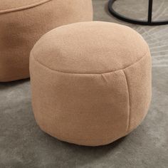 two round foot stools sitting on top of a carpeted floor next to each other