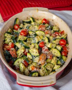 a casserole dish with zucchini, tomatoes and other veggies