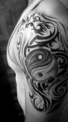 black and white photo of a man's arm with an intricate tattoo design on it