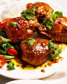 some meat and vegetables are on a plate with rice, sauce and cilantro