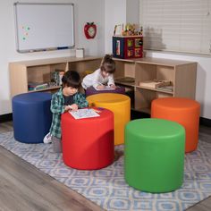 two children are sitting on colorful stools in the room