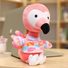 a pink stuffed animal sitting on top of a wooden table