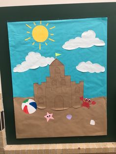 a bulletin board with a sandcastle and beach ball on it