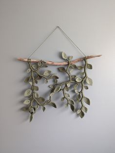 a wall hanging with leaves and branches on it